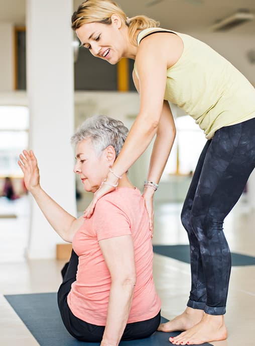 Yoga instructor helping client with exercises