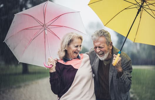 Couple walking with umbrellas