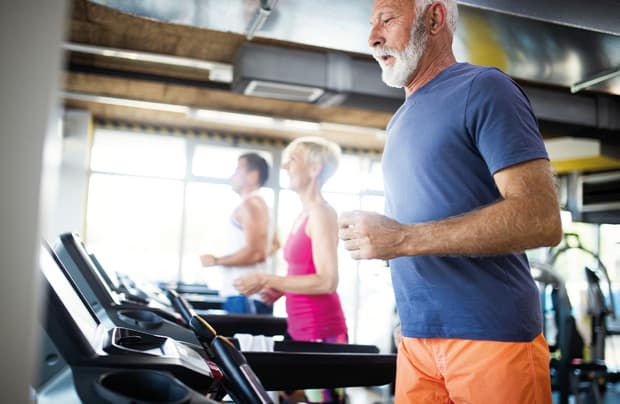 Seniors exercising on treadmills in gym