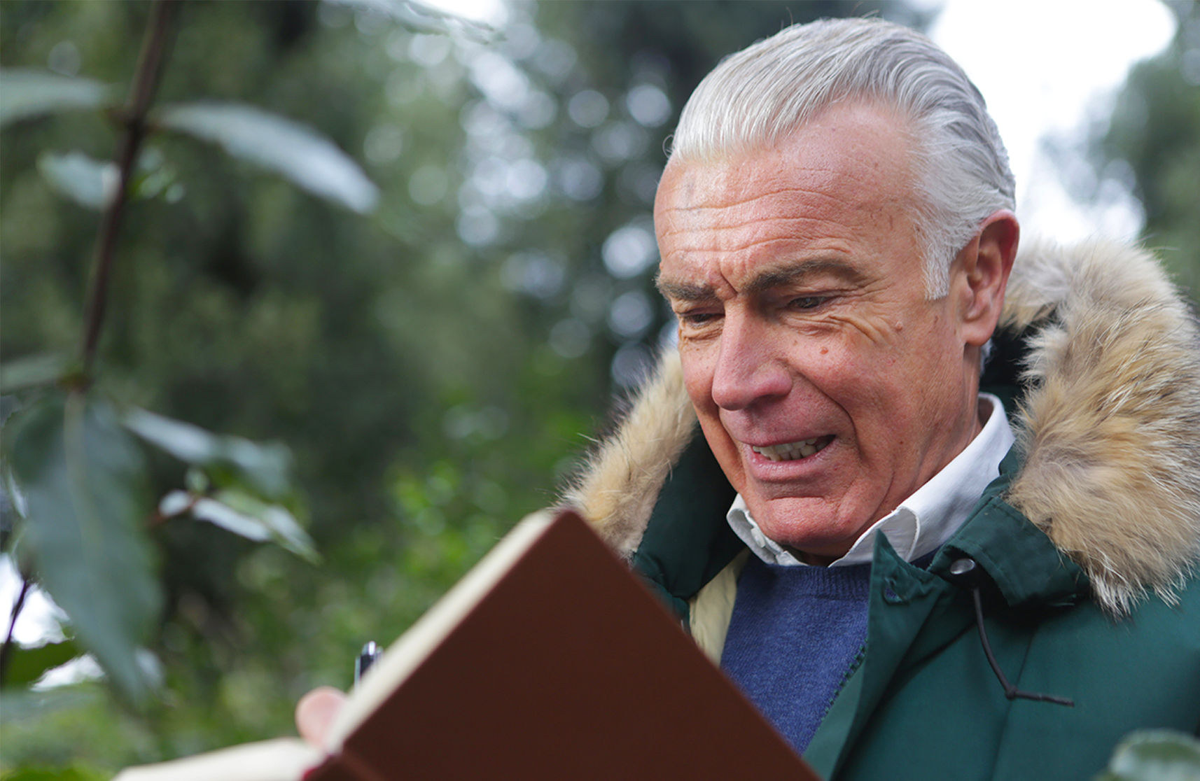 An image of a man in Burnham residential community, reading a book on site, representing winter activities.