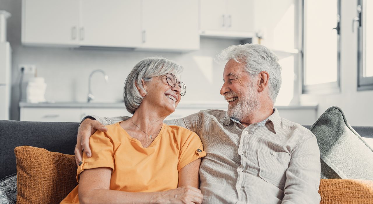 Burnham Waters in Essex - retired couple sat on sofa smiling