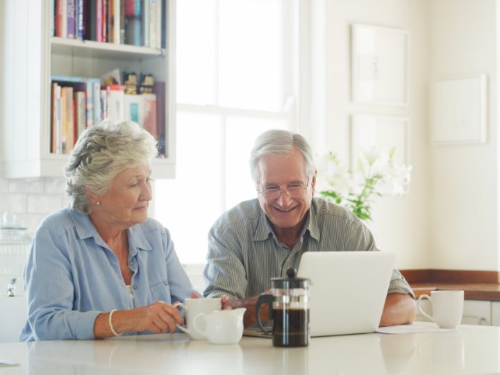 Older couple looking at laptop as latest technology supports independent living at Burnham Waters 