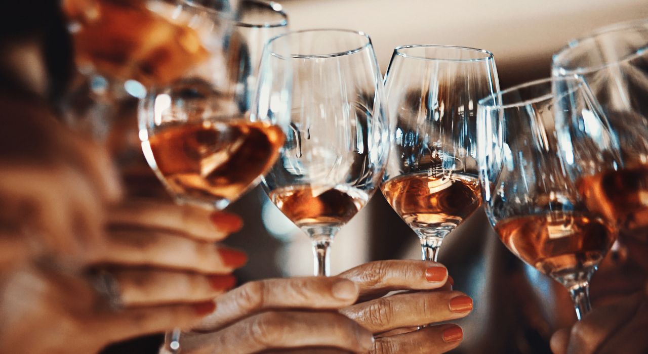 Senior living in Essex - wine tasting event Burnham Waters - hands holding wine glasses