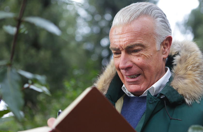 An image of a man in Burnham residential community, reading a book on site, representing winter activities.