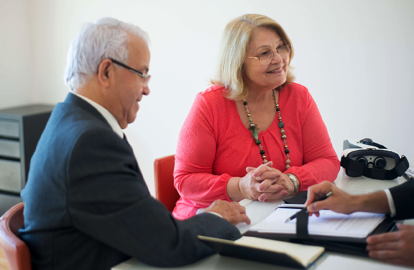 An image of an elderly couple enquiring about houses for over 55’s.