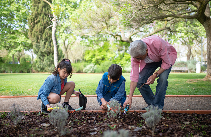 An image of a resident at one of the retirement villages in Essex gardening on Earth day with their grandchildren.
