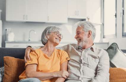 Burnham Waters in Essex - retired couple sat on sofa smiling