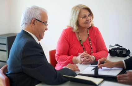 An image of an elderly couple enquiring about houses for over 55’s