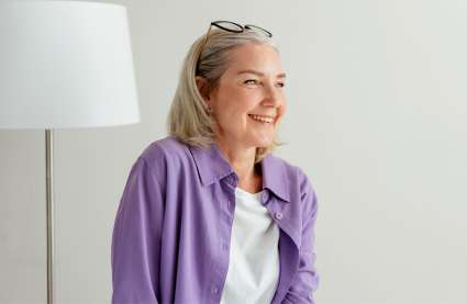 An image of a middle aged lady smiling to represent a happy retirement in an over–55s community near me.