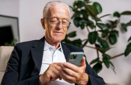 An image of a resident using their phone to represent the top apps for 55 and overs.
