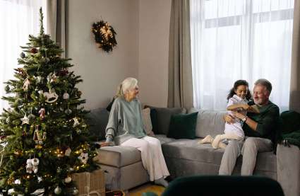 An image of an elderly couple with their grandchild in UK retirement villages, to represent things to enjoy December. 